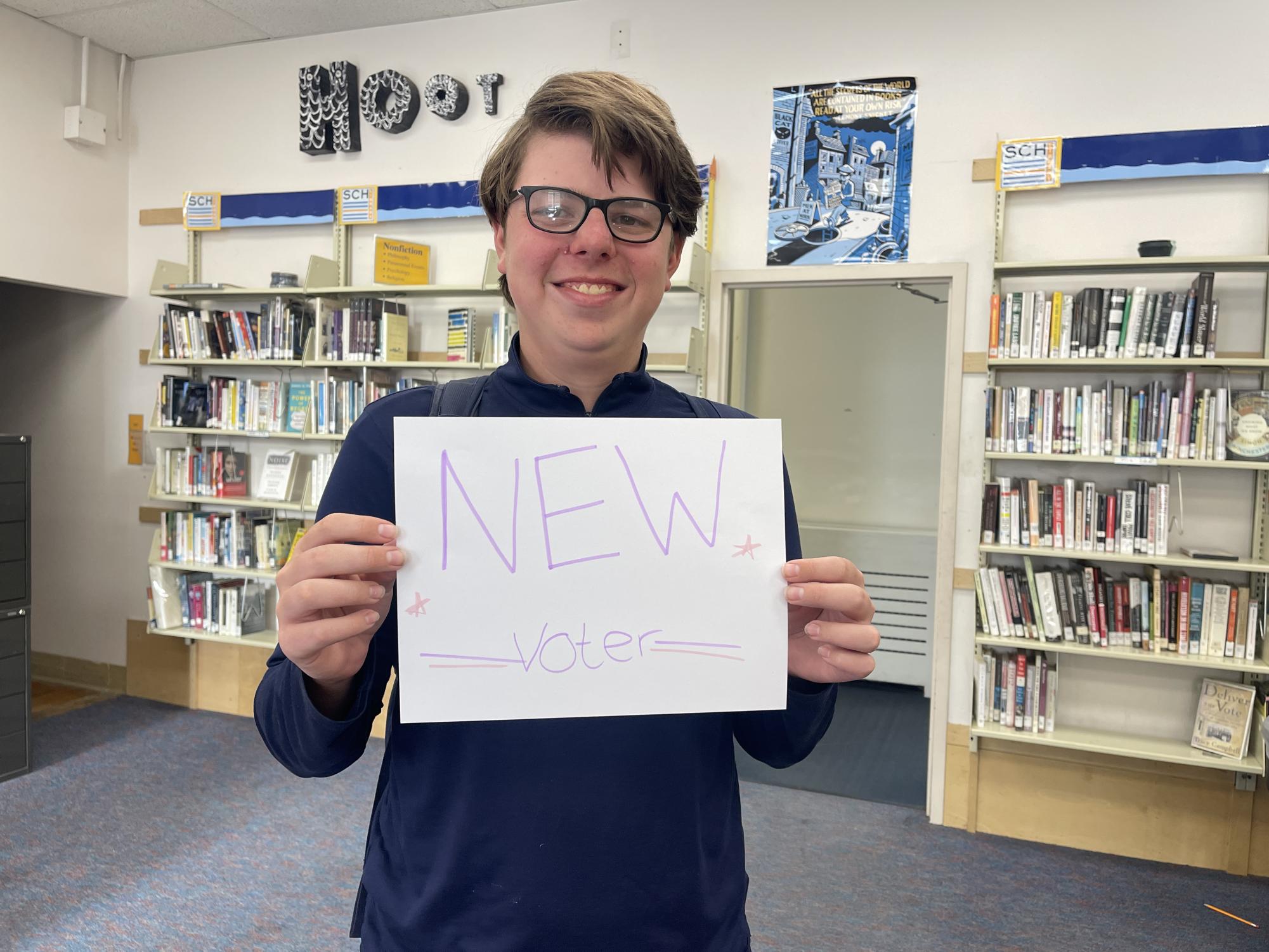 Brendan Flatow holding new voters sign 