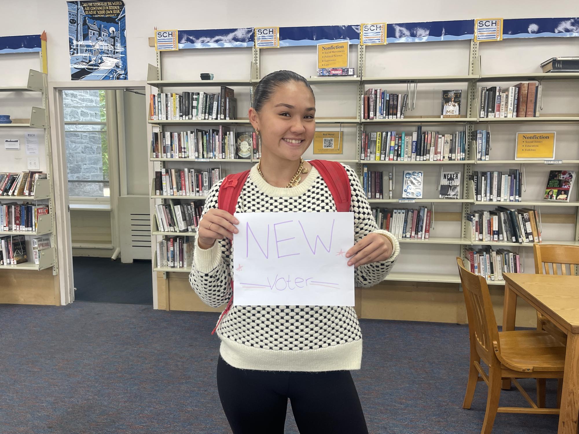 Gracyn Lee-Torchiana '25 holds a new voters sign 