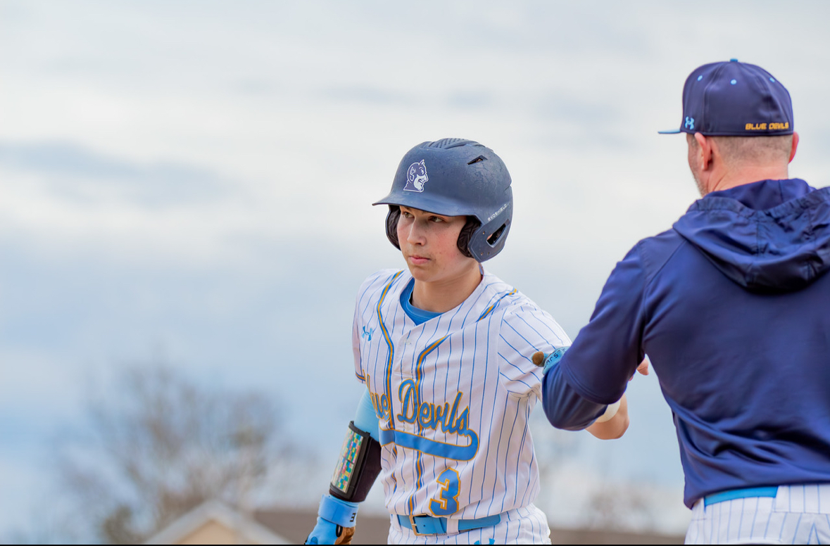 Dax Caplan fist bumps Coach Brown after reaching base vs Bonner