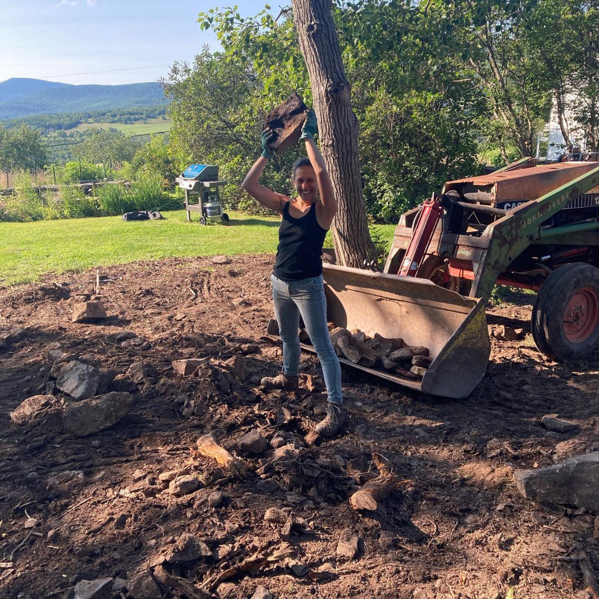 Ms. Gellhorn clears boulders from land where she will eventually plant grass. 