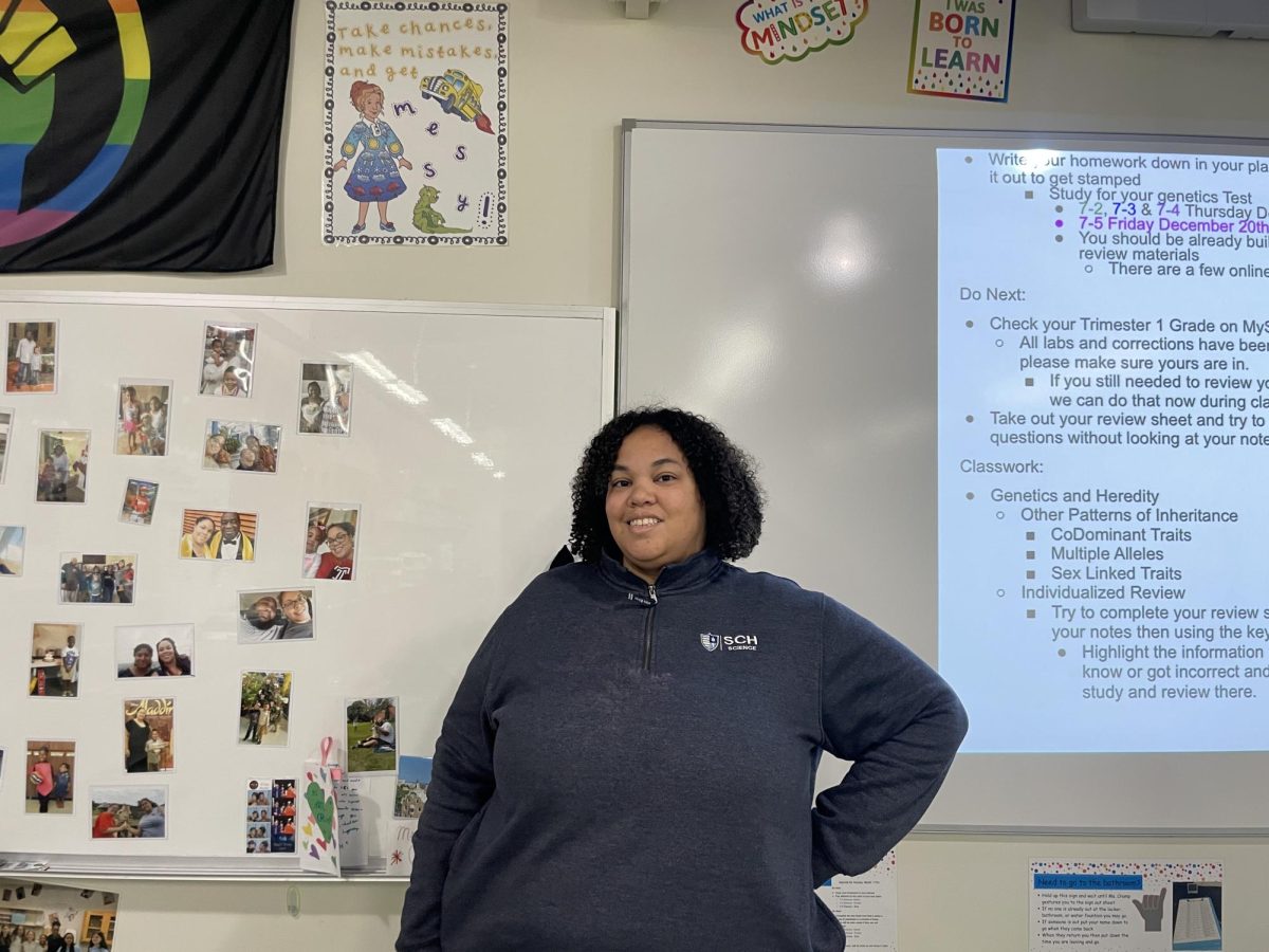 Ms. Kathryn Crump in front of her Miss. Frizzle poster in her classroom. 