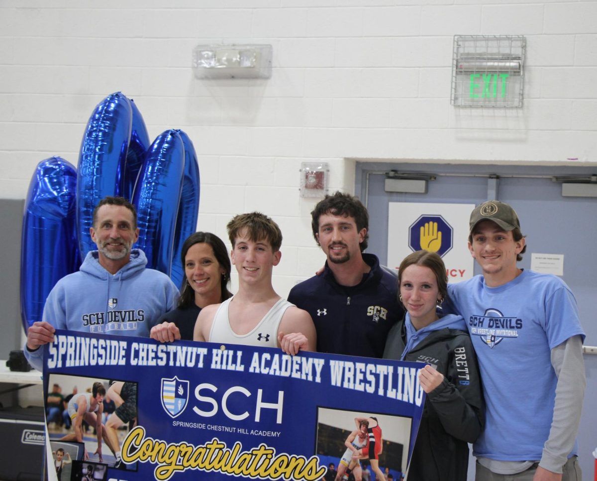 Sean Brett '25 celebrates with his family - his two older brothers are assistant coaches on the wrestling team - after his 100th win