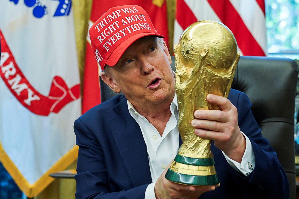U.S. President Donald Trump wears a 'Trump Was Right About Everything!' hat while holding the FIFA World Cup Trophy, as he makes an announcement on the 2026 FIFA World Cup, in the Oval Office at the White House in Washington, D.C., U.S., August 22, 2025. REUTERS/Jonathan Ernst