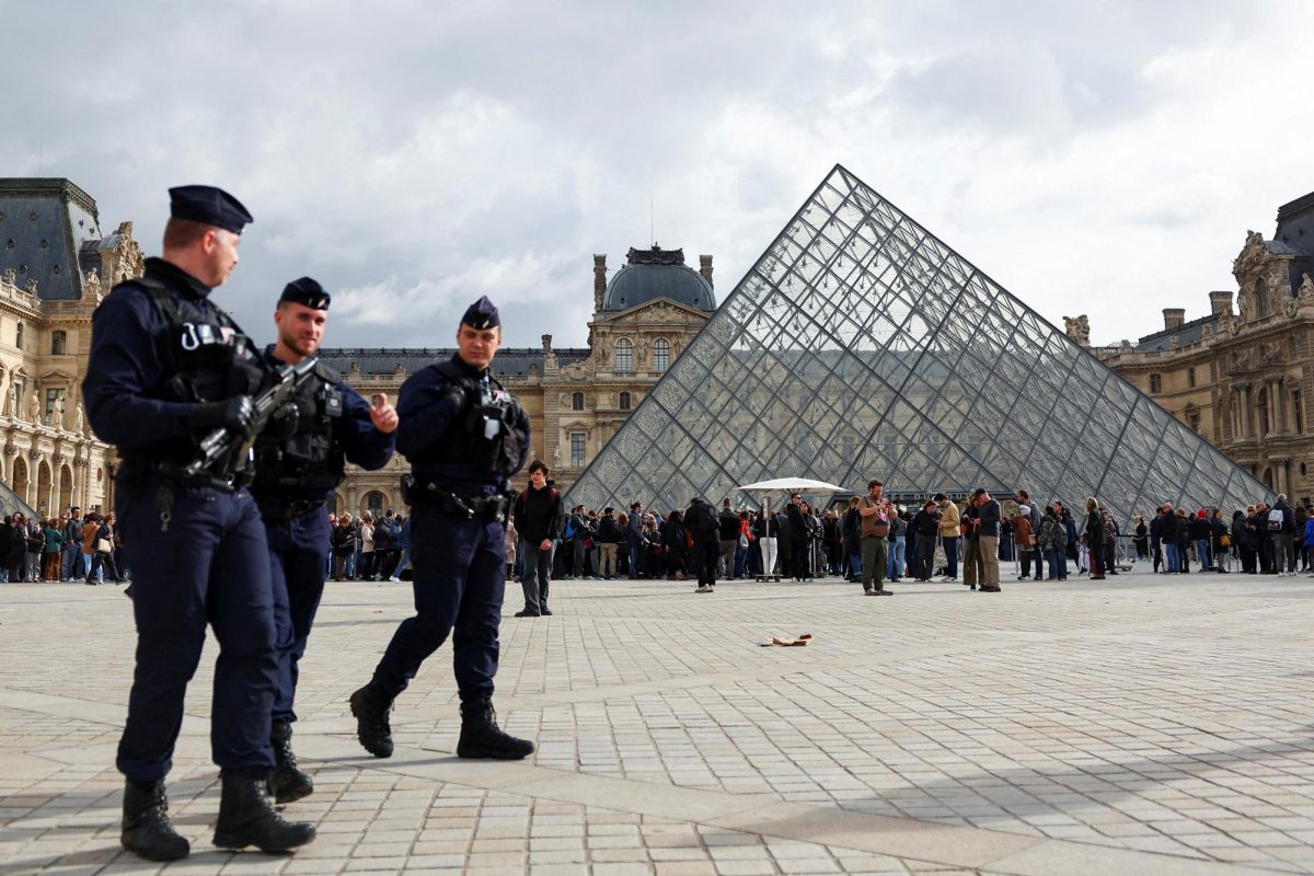 French CRS riot police officers walk near the glass Pyramid of the Louvre Museum, after French police arrested suspects in the Louvre heist case, in Paris, France October 27, 2025. REUTERS/Abdul Saboor