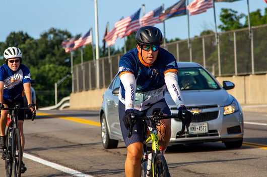 Jason Maher cycles alongside cars during the Empire State Ride