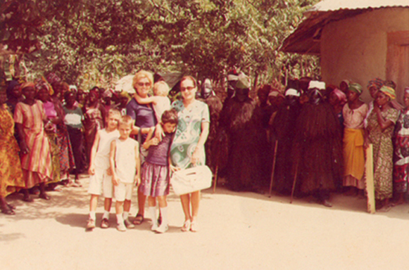 "Here we are in the deep bush (rain forest) of Liberia, visiting a Vai tribe - notice the masks to the right in the background. My father was writing an article about them for African Arts magazine in 1972. " — Pia Druggan